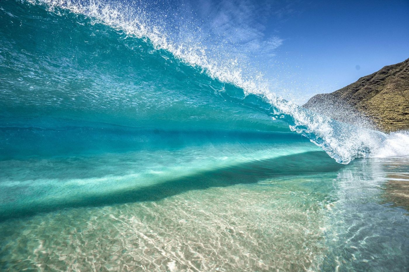 A green wave breaking on Seven Mile Beach